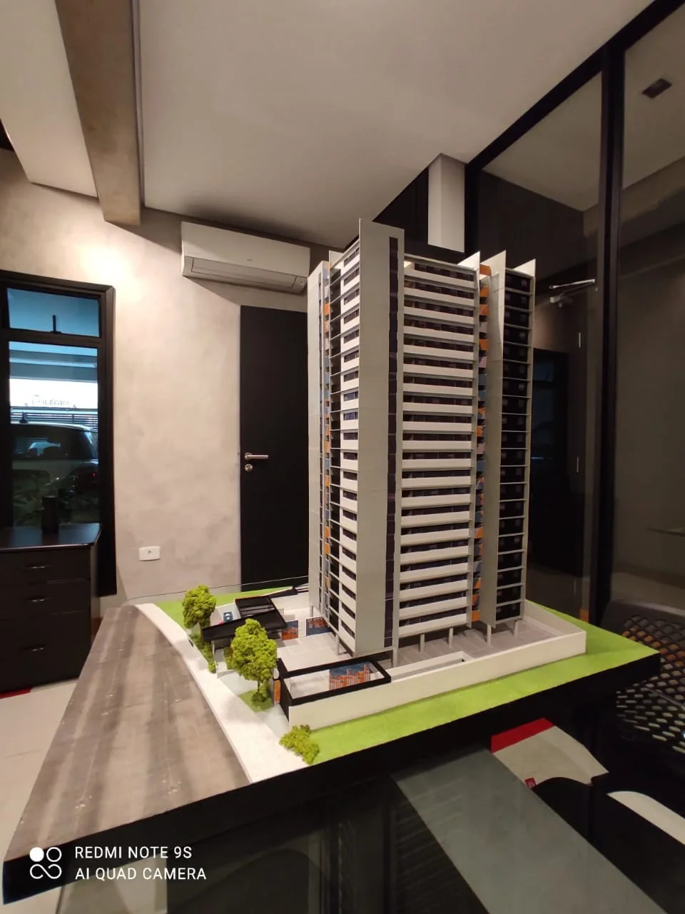 Modelo físico de torre residencial com iluminação em ambiente interno