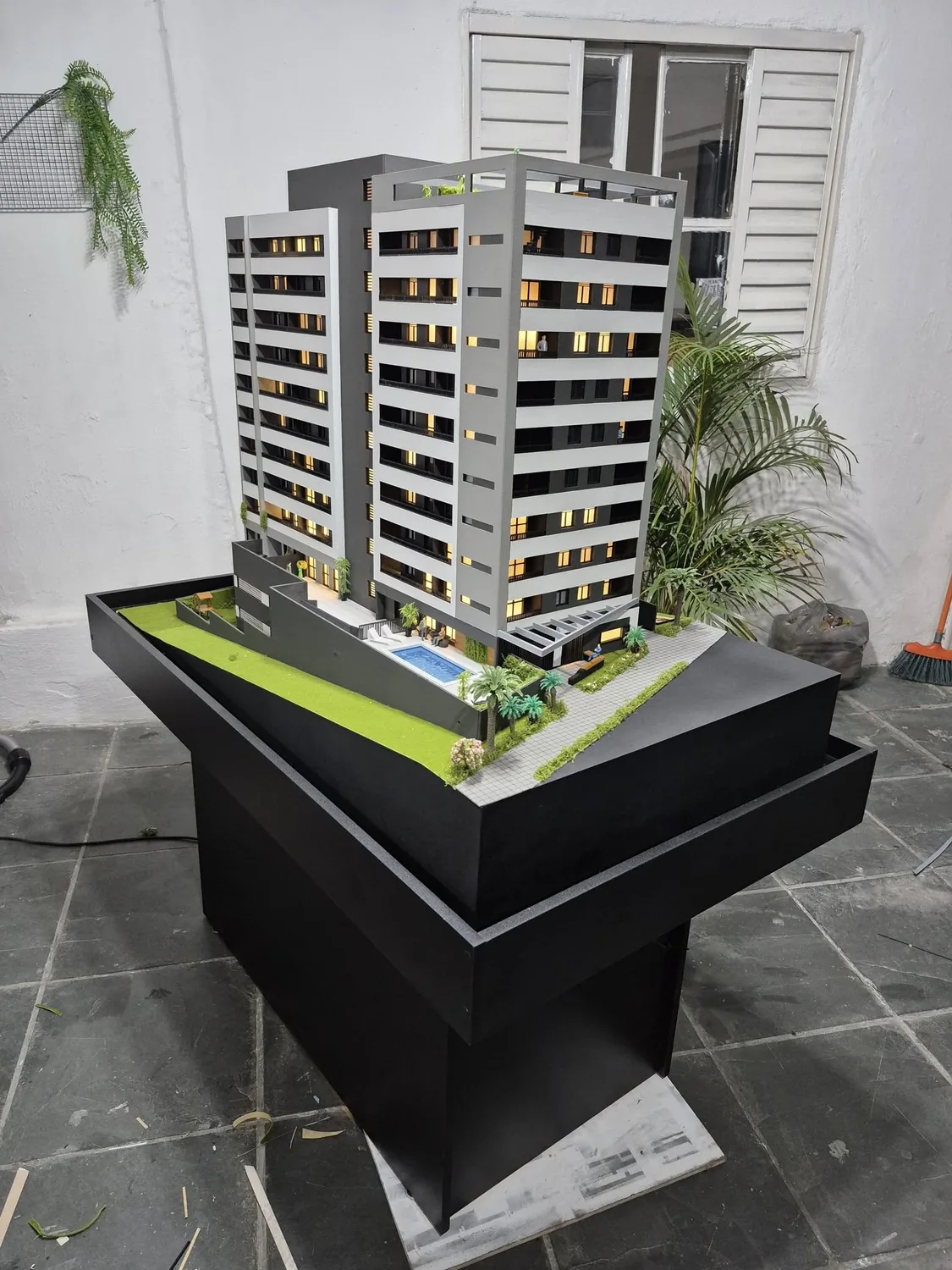 Maquete de prédio residencial apresentada em pedestal preto